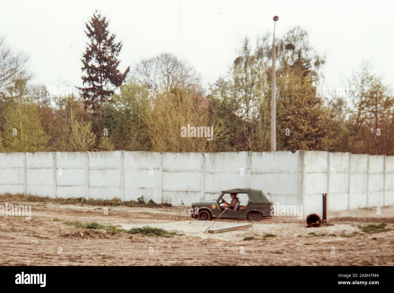 Michael Scott/Alamy Live Nachrichten - Berlin, Deutschland April 1990 - Ein Ostdeutscher Soldaten Streifen Niemandsland zwischen den Wänden in einer Armee Trabant. Osten deutsche Soldaten waren noch an Aufgaben sogar Monate tragen, nachdem die Mauer fiel. Am Stadtrand von Berlin fotografiert im April 1990 Monate nach dem Fall der Berliner Mauer im Jahr 1989. Stockfoto