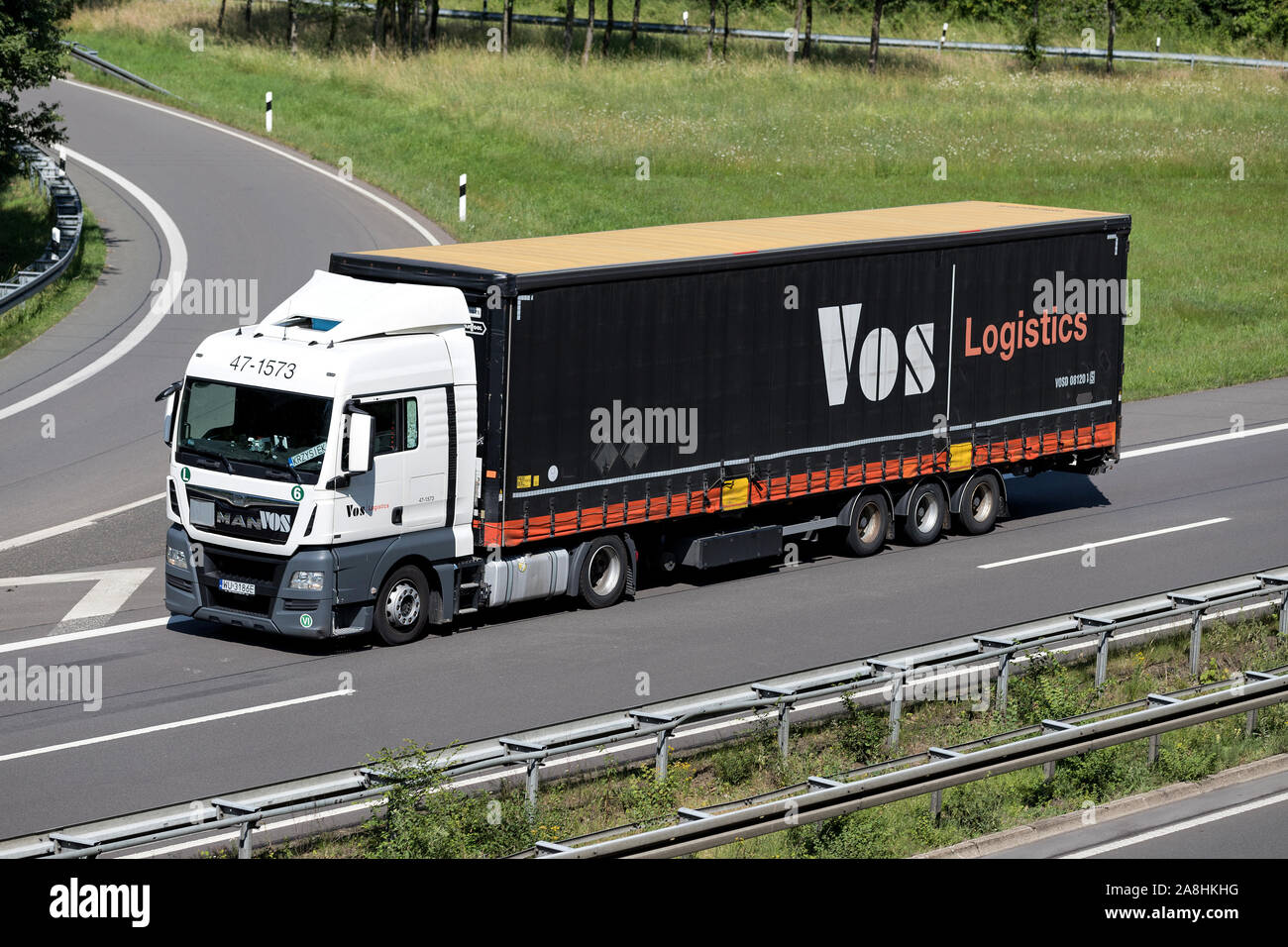 VOS MAN Lkw mit curtainside Anhänger auf der Autobahn. Stockfoto