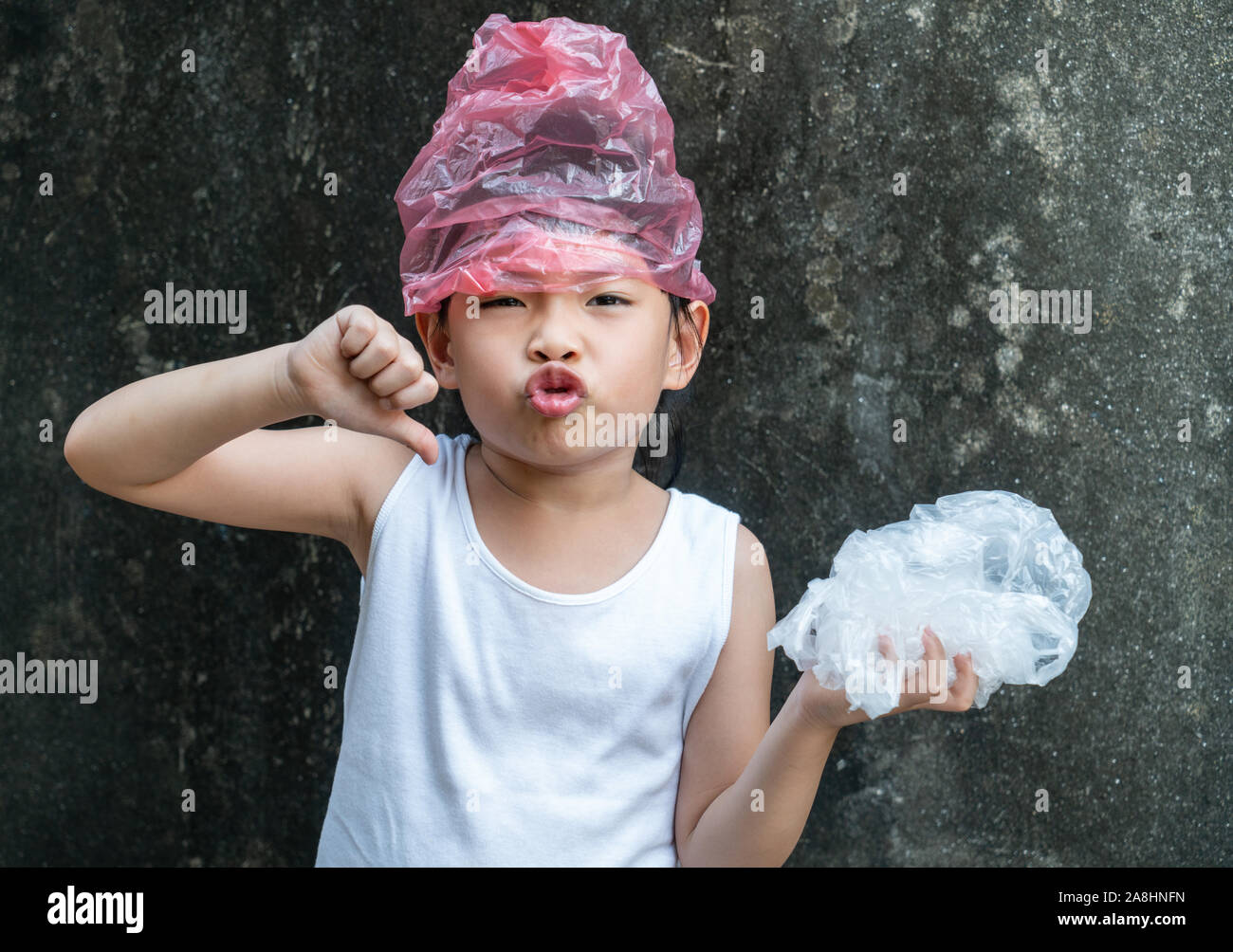 Süße kleine Mädchen posiert mit Plastiktüten. Konzept für die Anwendung von Plastikbeutel. Stockfoto