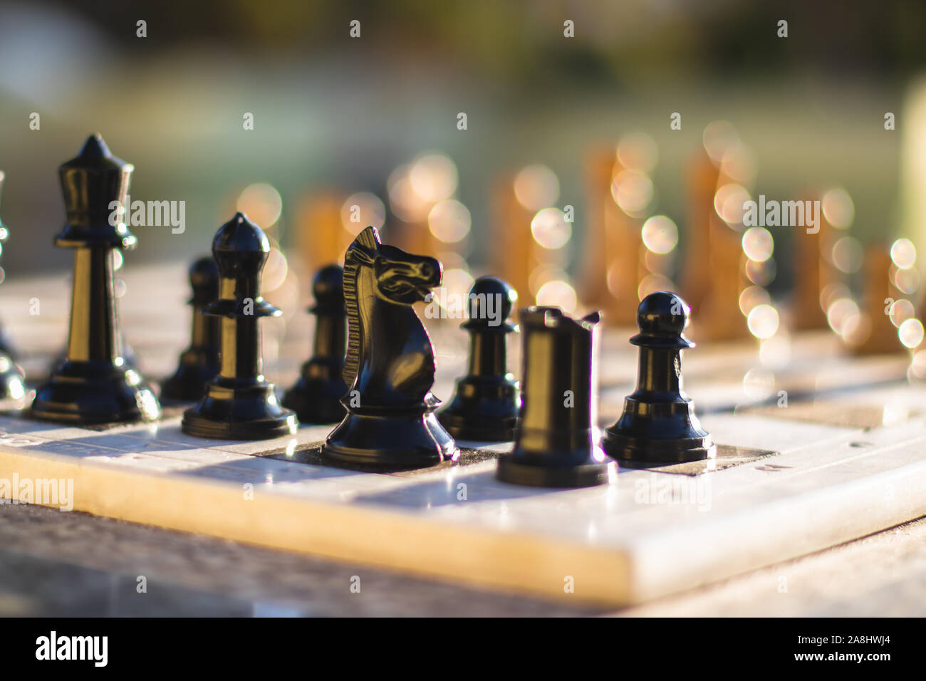 Schachfiguren auf einem Schachbrett in einer strategischen Schachspiel in einen Park. Stockfoto