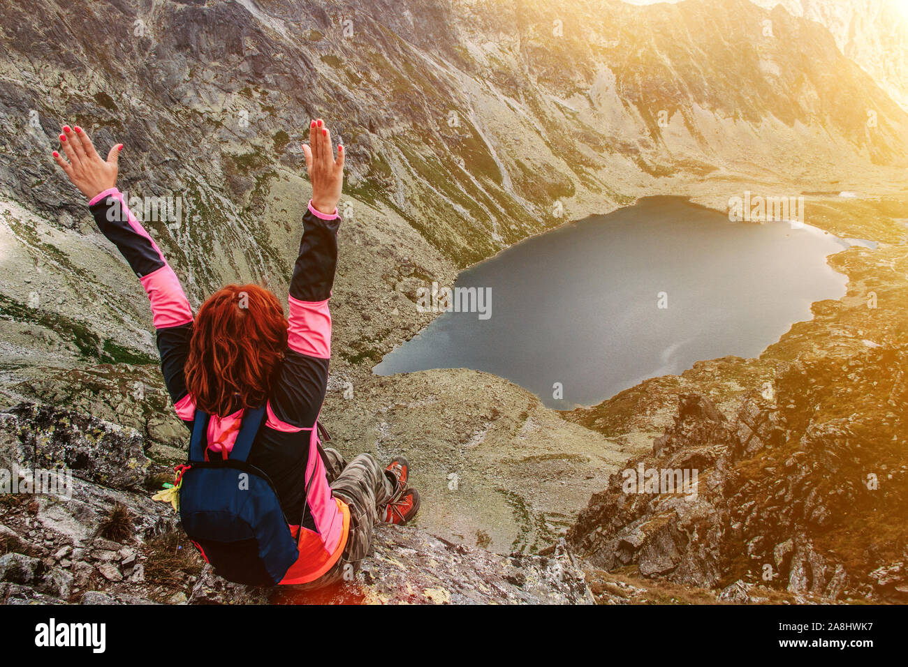 Mountain Lake malerische Landschaft. Hohe Felsen. Schöne Landschaft. Die Slowakei, Hohe Tatra. Happy Reisen Frau sitzt auf dem Gipfel. Stockfoto