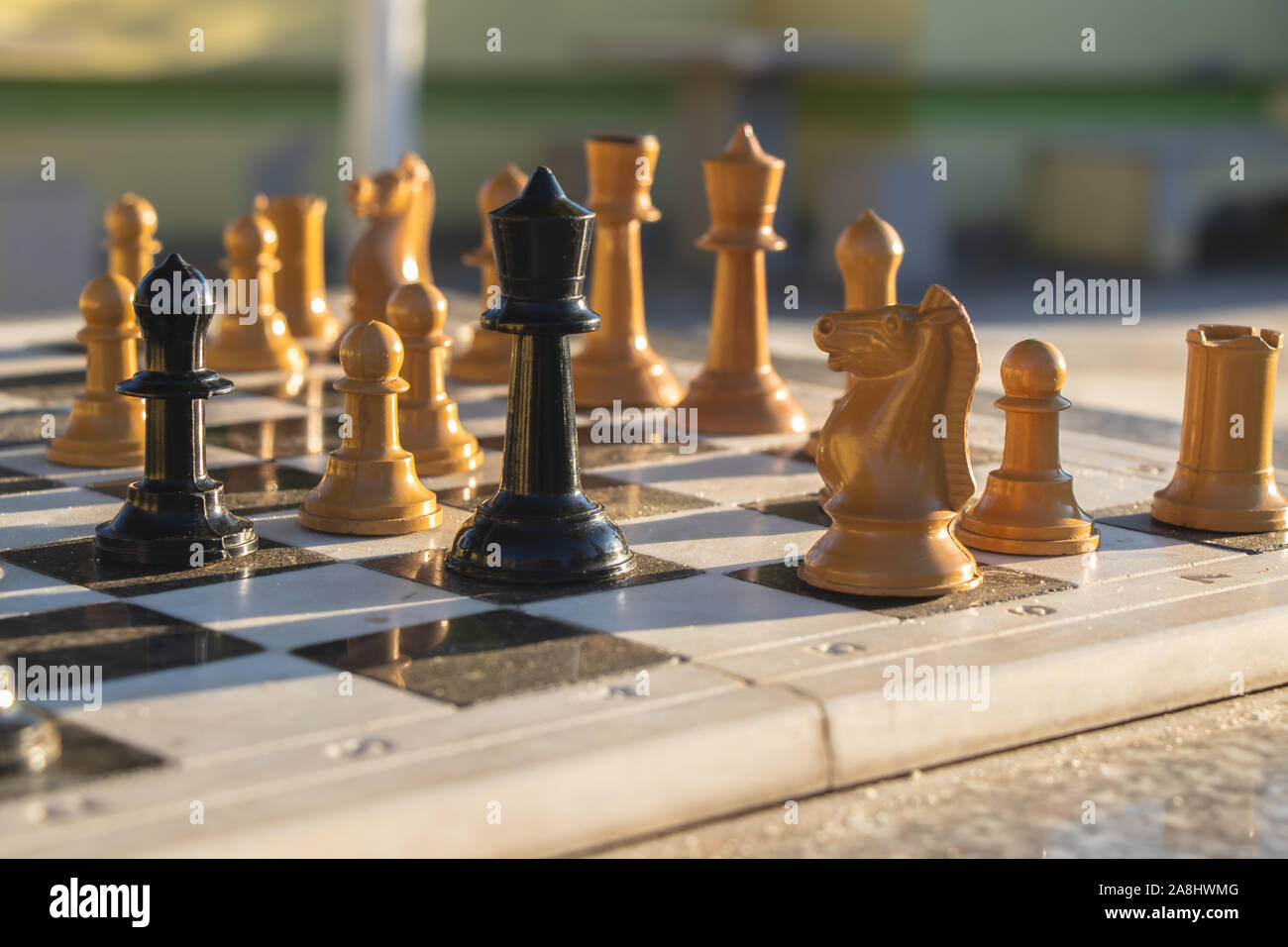 Schachfiguren auf einem Schachbrett in einer strategischen Schachspiel in einen Park. Stockfoto