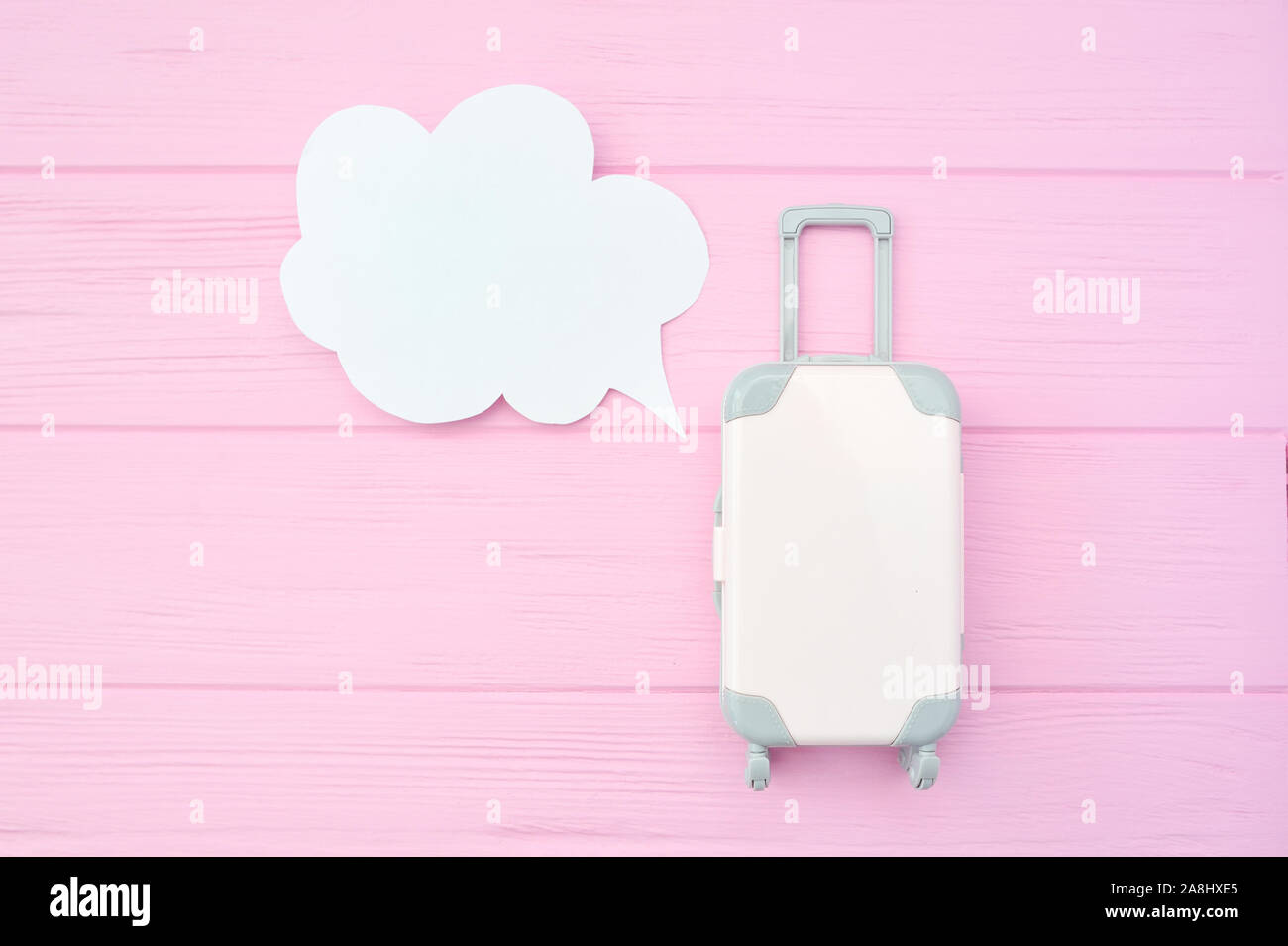 Koffer mit Sprechblase auf rosa Hintergrund. Konzept für Reise und Tourismus, mit Platz für Ihren Text Stockfoto Koffer mit Sprechblase auf rosa Hintergrund. Konzept für Reise und Tourismus, mit Platz für Ihren Text Stockfoto