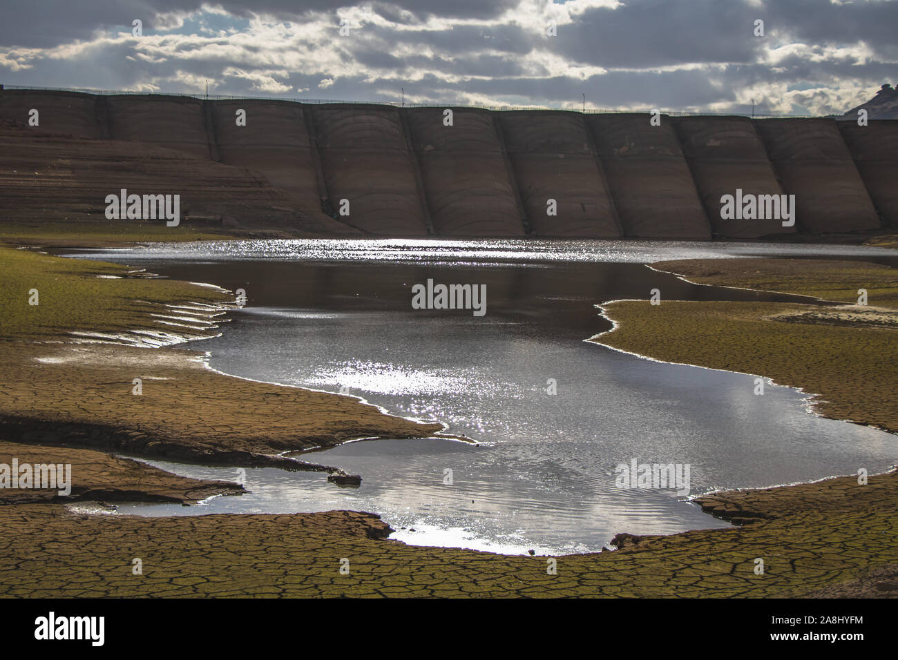 Damm und ein kleiner See in einem trockenen, ausgetrockneten Boden. Wüste. Globale Erwärmung. Stockfoto
