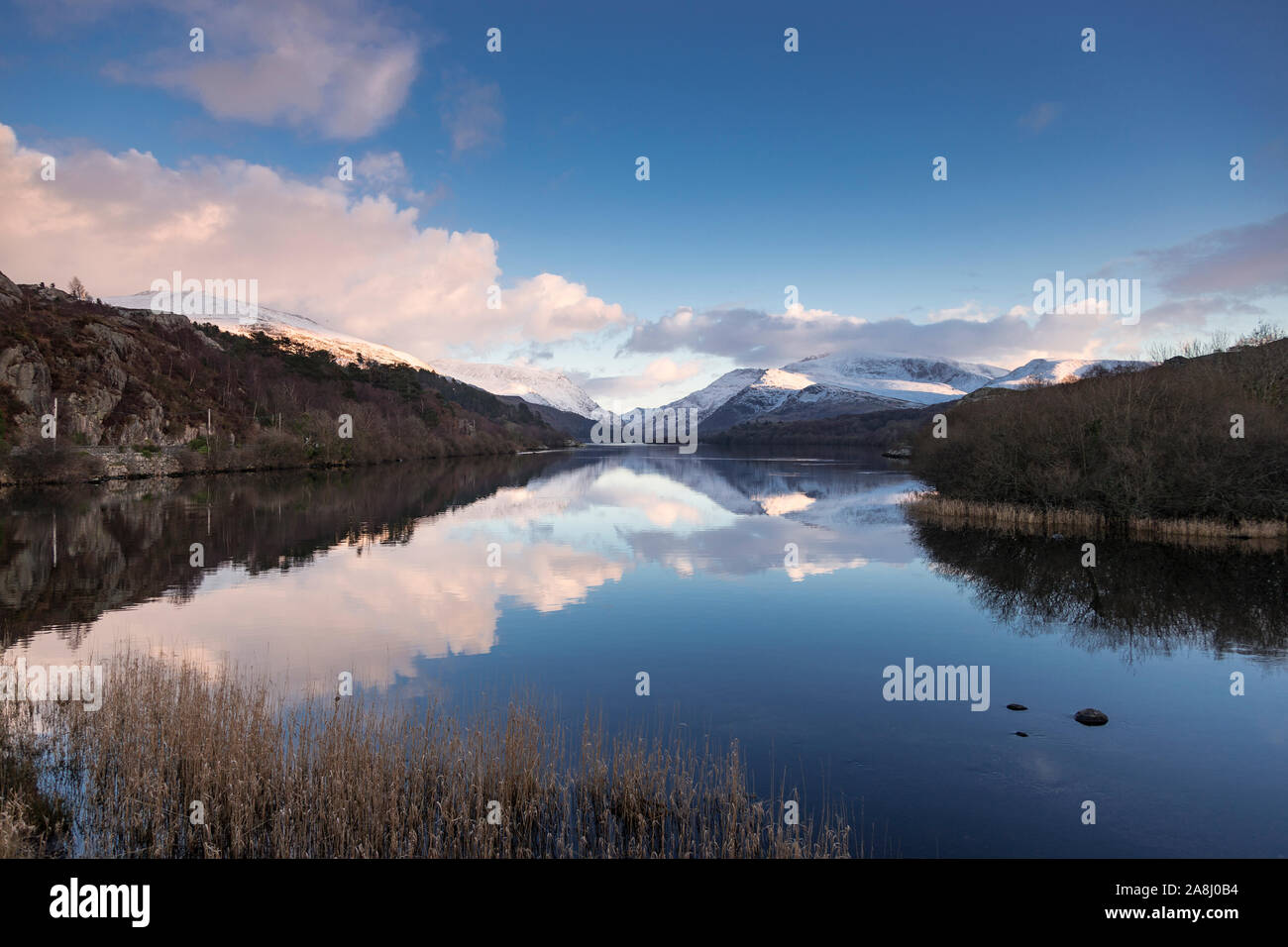 Llyn Padarn, Snowdonia, im Winter mit Schnee bedeckten Bergen Stockfoto
