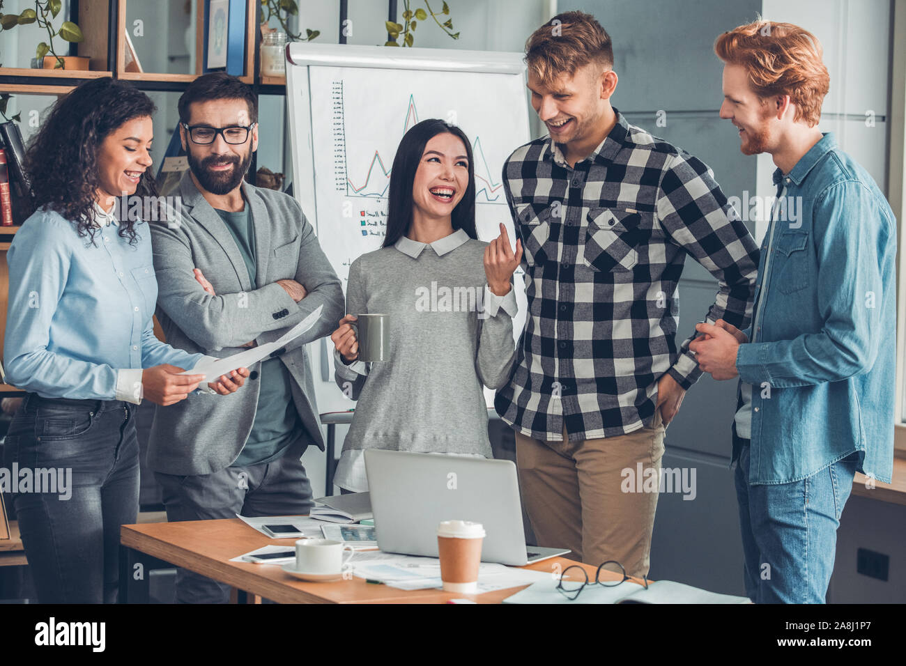 Startupers zusammen arbeiten im Büro stehen Reden lächeln lachen heiter Stockfoto