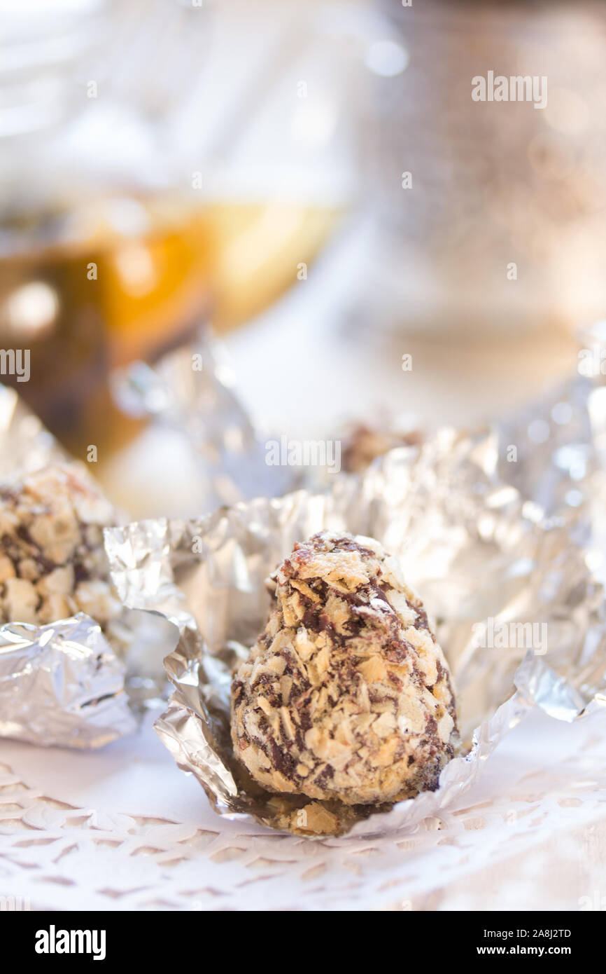 Bonbons in Schokolade und zerdrückten Wafer auf einem weißen Tisch Stockfoto