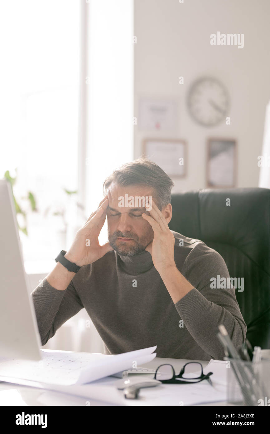 Reifen müde Geschäftsmann mit geschlossenen Augen, die versuchen, von Arbeitsplatz zu konzentrieren Stockfoto