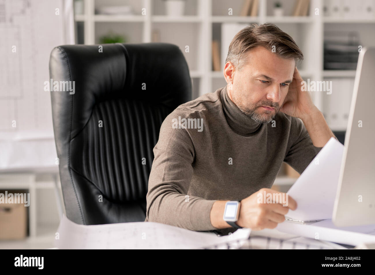 Reifen Ingenieur mit Papieren suchen in einer der Skizzen, während Sie prüfen Stockfoto
