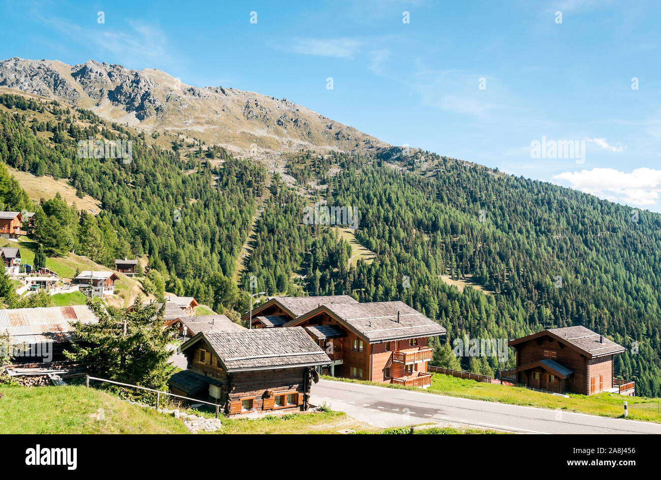 Holzhäuser in den Wiesen des Schweizer Alpen im Saint Luc Tal an einem sonnigen Tag. Stockfoto