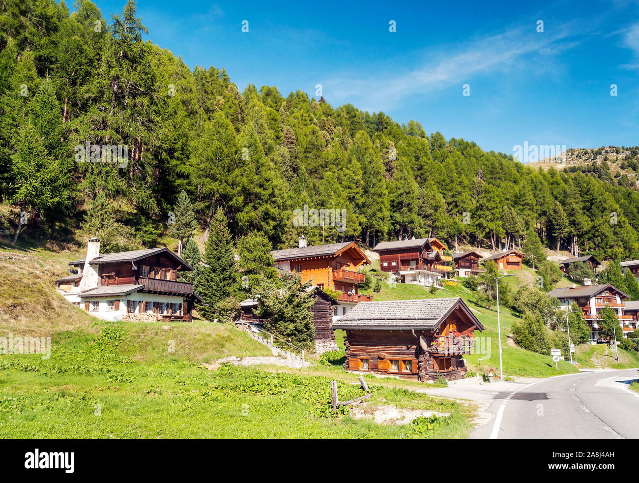 Holzhäuser in den Wiesen des Schweizer Alpen im Saint Luc Tal an einem sonnigen Tag. Stockfoto