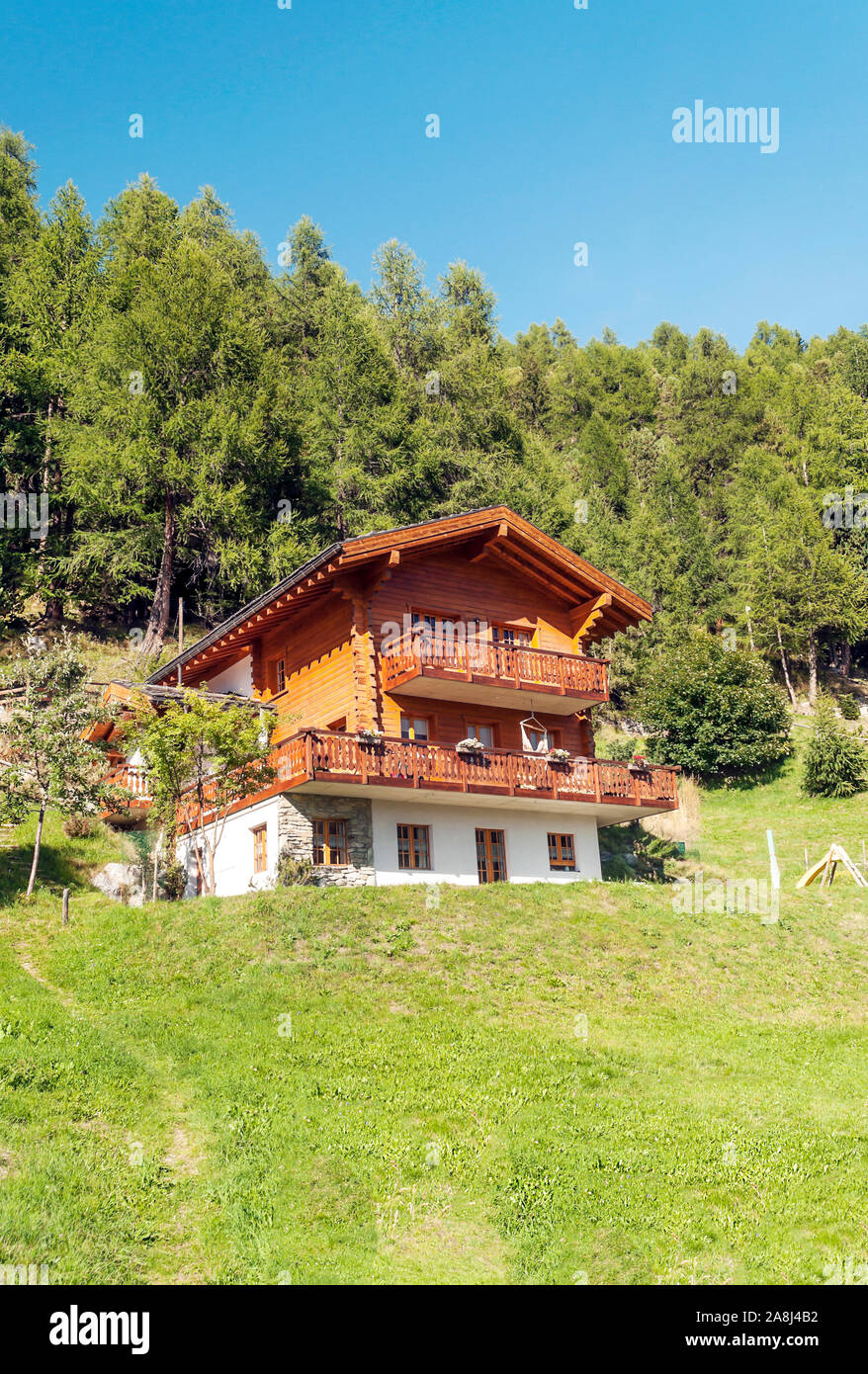 Holzhäuser in den Wiesen des Schweizer Alpen im Saint Luc Tal an einem sonnigen Tag. Stockfoto