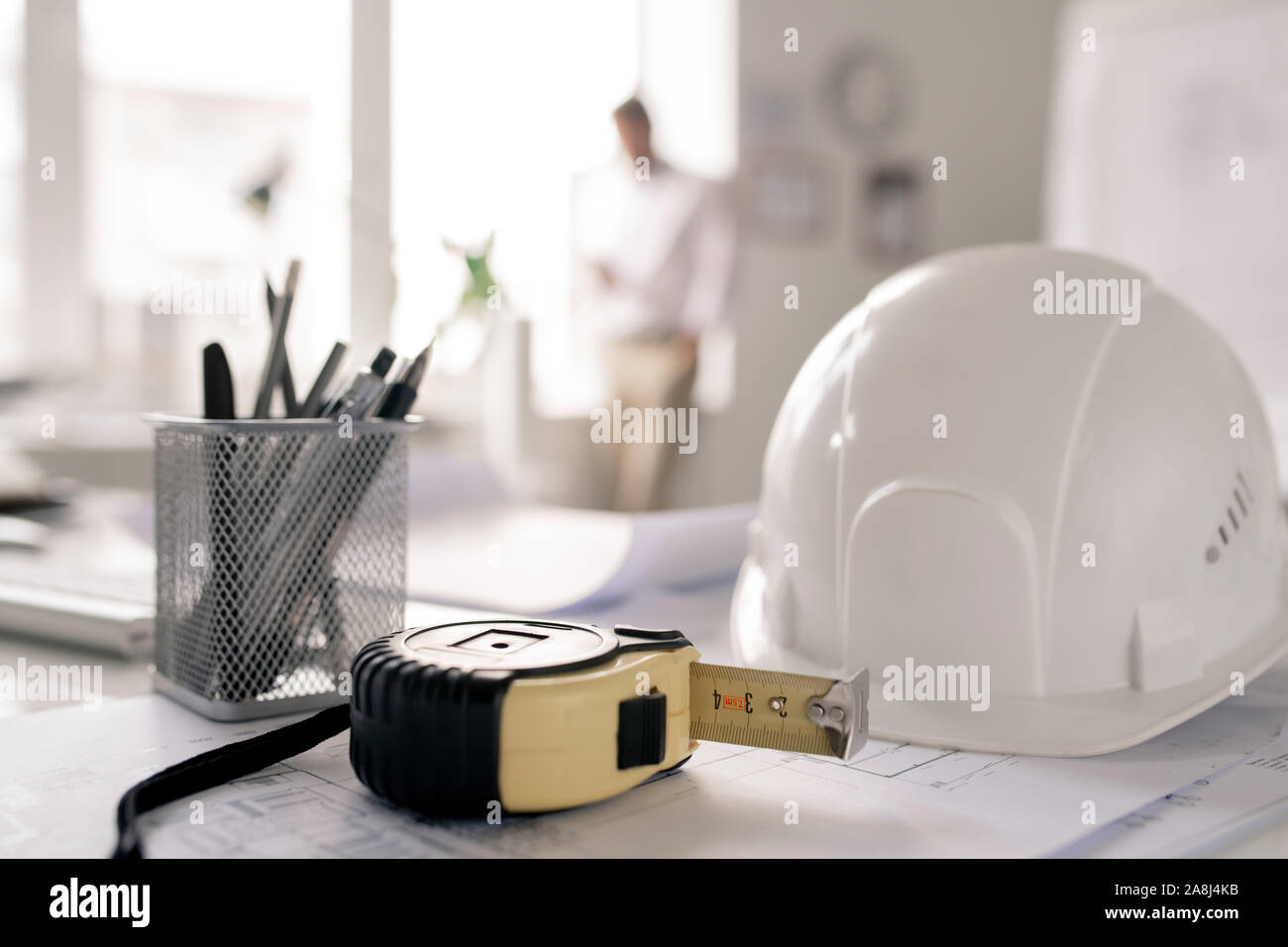 Arbeitsplatz der Ingenieur mit hardhat, Maßband, Bündel Bleistifte und Skizze Stockfoto