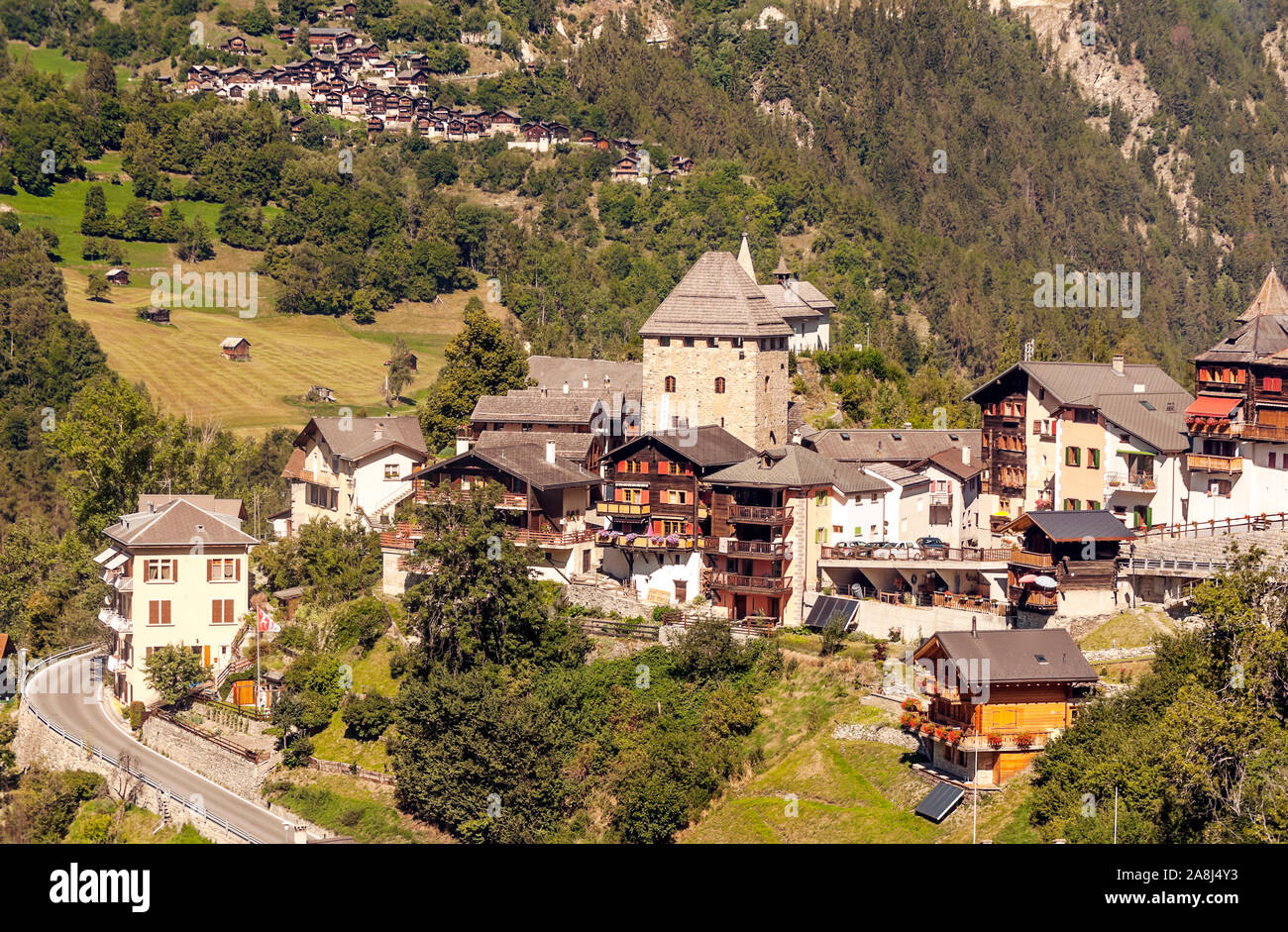 Holzhäuser in den Wiesen des Schweizer Alpen im Saint Luc Tal an einem sonnigen Tag. Stockfoto