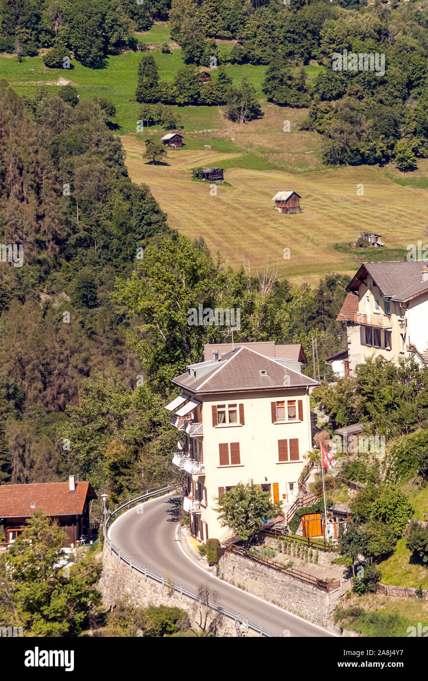 Holzhäuser in den Wiesen des Schweizer Alpen im Saint Luc Tal an einem sonnigen Tag. Stockfoto