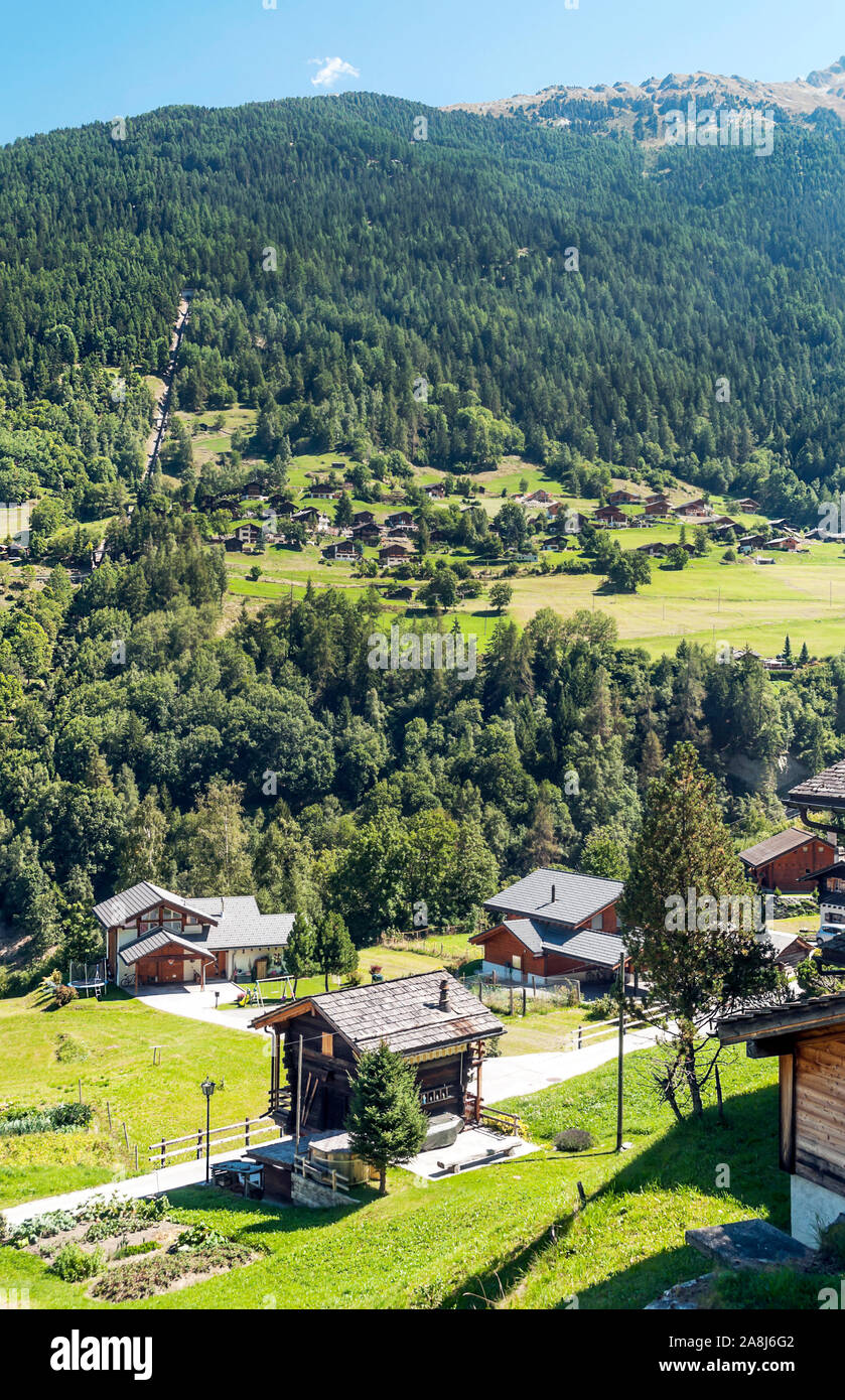 Holzhäuser in den Wiesen des Schweizer Alpen im Saint Luc Tal an einem sonnigen Tag. Stockfoto