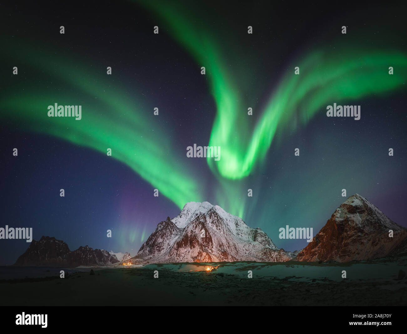 Aurora borealis in Lofoten Inseln, Norwegen. Winter kalte Nacht und das Nordlicht. Verschneiten Gipfeln und eine arktische Strand Stockfoto