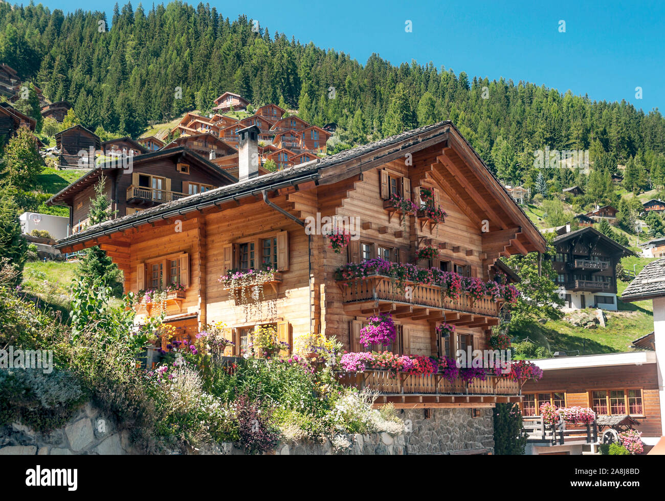 Holzhäuser in den Wiesen des Schweizer Alpen im Saint Luc Tal an einem sonnigen Tag. Stockfoto