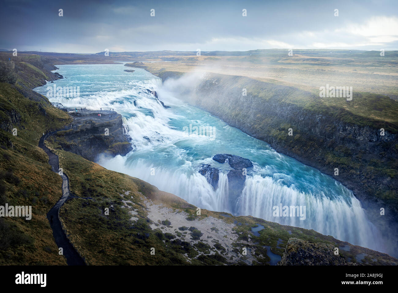 Schöne türkisblaue Wasserfall in Island. Herbst bewölkten Tag, Gras. Bekannte touristische Destination. glazialen reines Wasser. Stockfoto