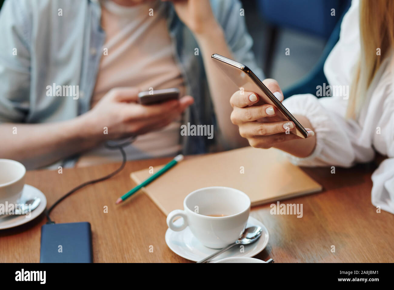 Die Hand der jungen Frau mit Handy Smartphone Scrollen durch Kontakte Stockfoto