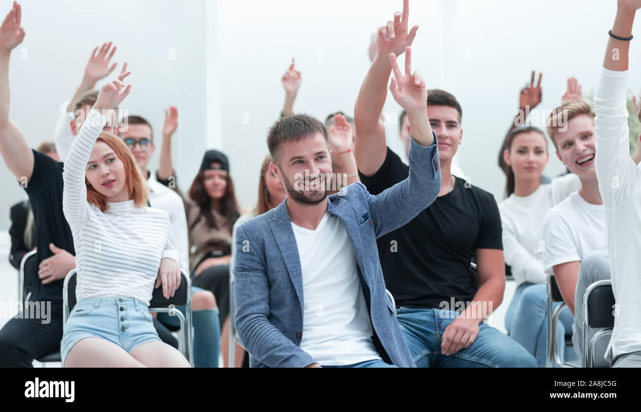 Gruppe junger Menschen erhöhen ihre Hände, um eine Frage zu stellen. Stockfoto