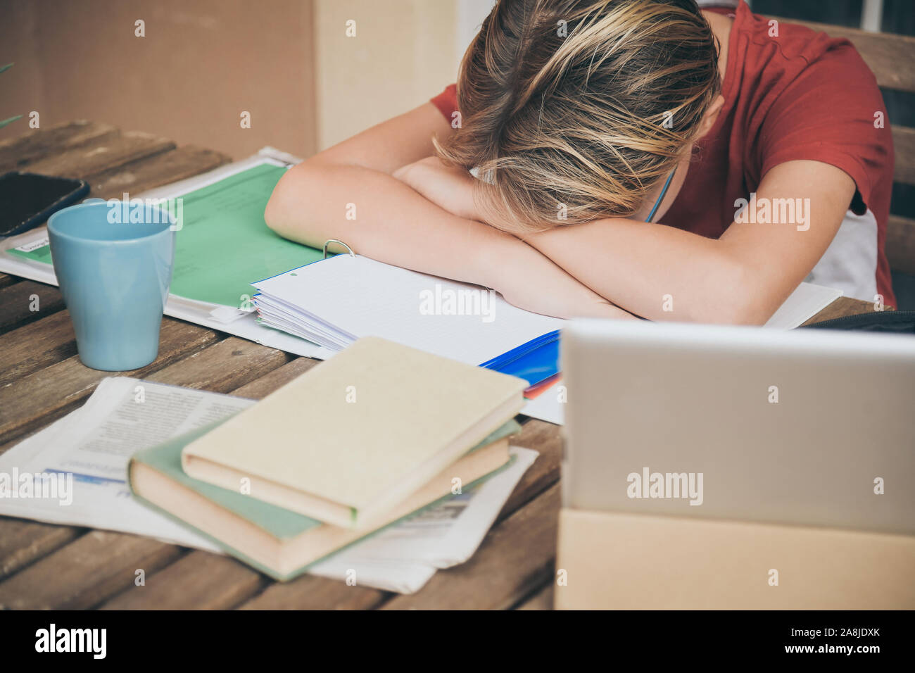 Müde Schüler Hausaufgaben zu Hause sitzen im Freien mit Schule Bücher und Zeitungen. Junge müde wegen der schweren studieren. Kind schlafend auf dem copybook nach l Stockfoto