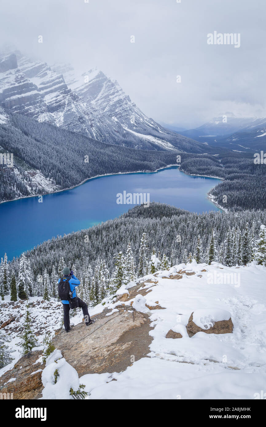 Fotograf am Peyto Lake, Kanadischen Rocky, Rocky Mountains, Kanada. Schnee und bewölkt. Blaues Wasser. Abenteurer. Stockfoto