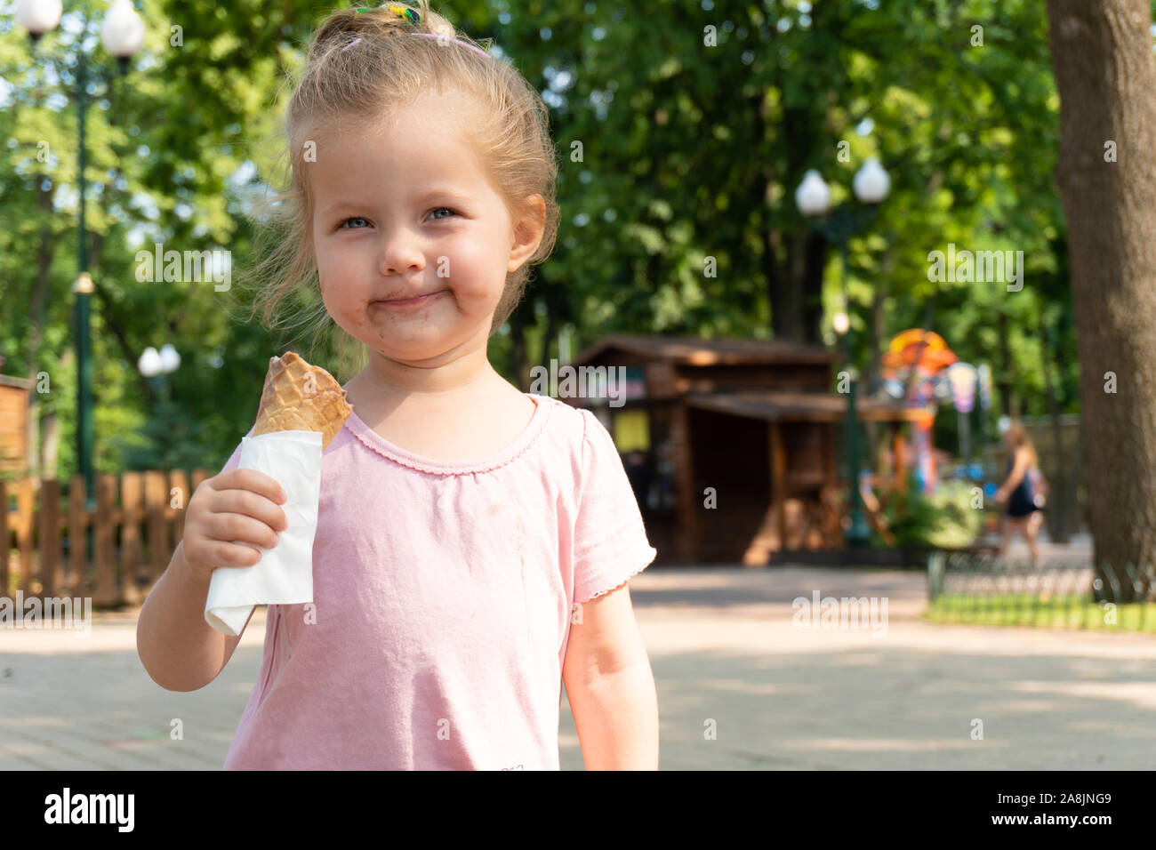 Kleines Mädchen mit einem Eis und Gesicht in der Schokolade Stockfoto