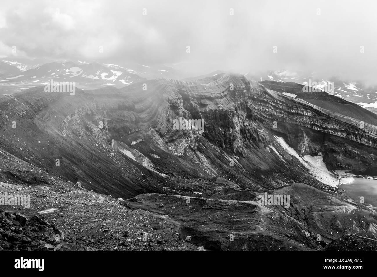 Die Caldera des Vulkans Gorely in der Bewölkung, Kamtschatka, Russland. Schwarz/Weiß-Bild Stockfoto