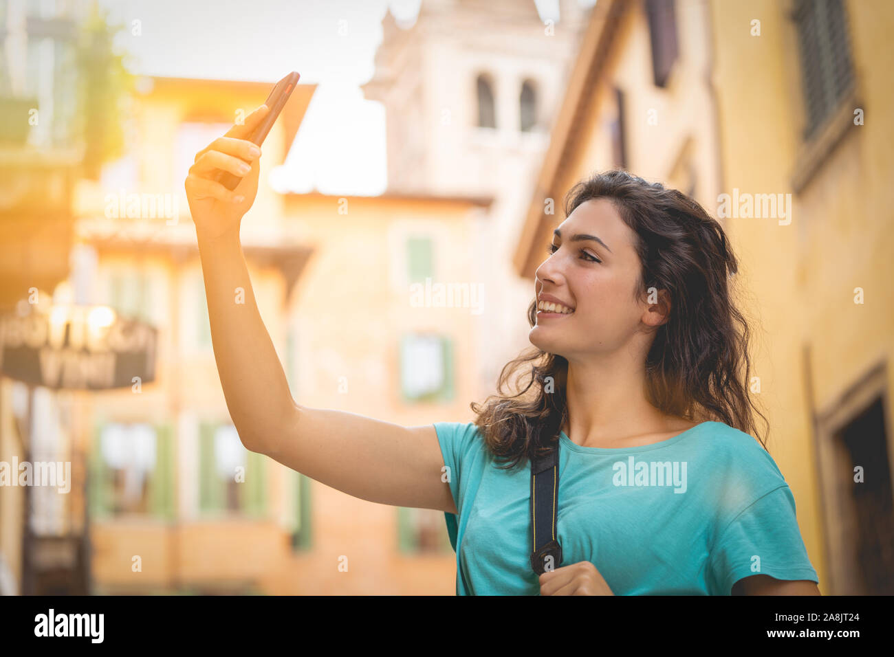 Touristische Mädchen auf Urlaub in Verona ein selfie auf eine typische Straße Stockfoto