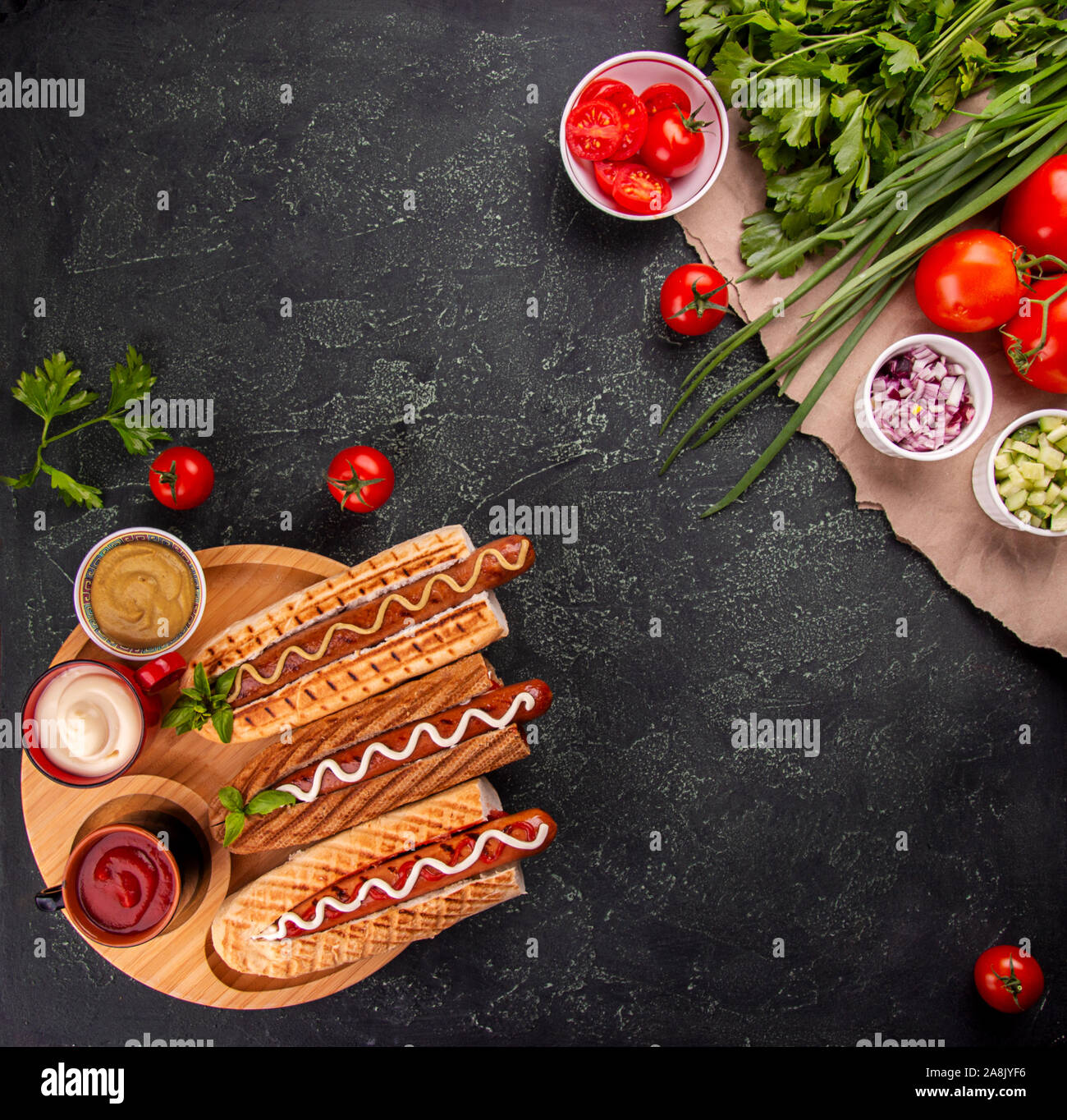 Hot Dogs, Gemüse und sauses auf schwarzem Hintergrund. Fast food, amerikanische tradditional Essen. top View. Kopieren Sie Platz Stockfoto