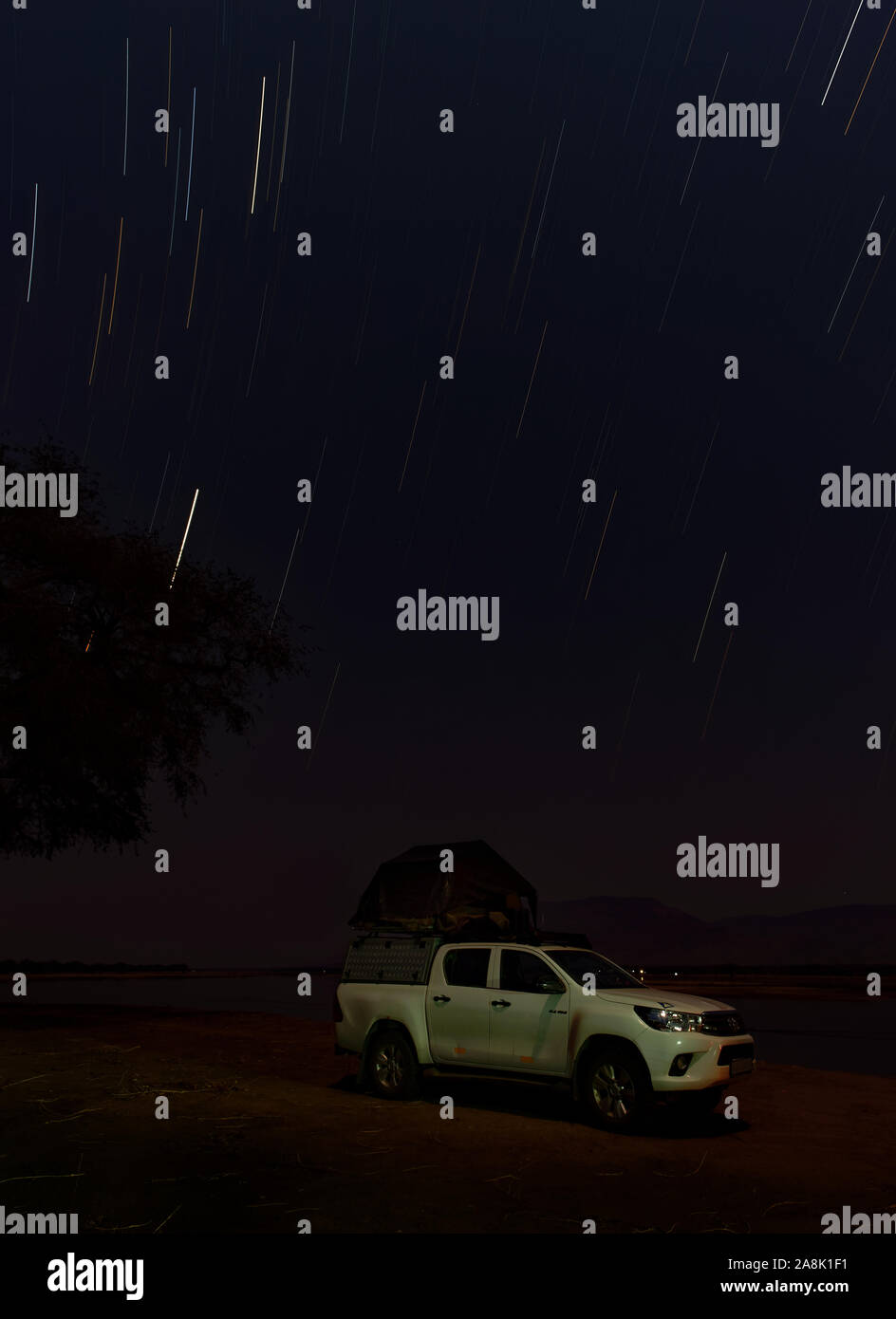 Safari im eigenen Pkw mit Zelt auf dem Dach, am Ufer des Sambesi in Simbabwe schlafen, Stern am Himmel und Nacht Bild. Stockfoto