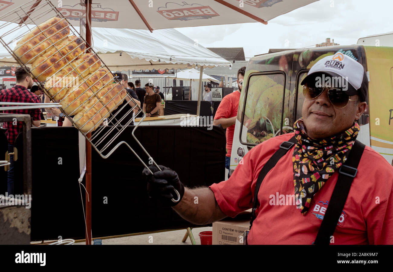 Ein Mann hält ein Gitter mit Knoblauch Brot in der Sonne Stockfoto