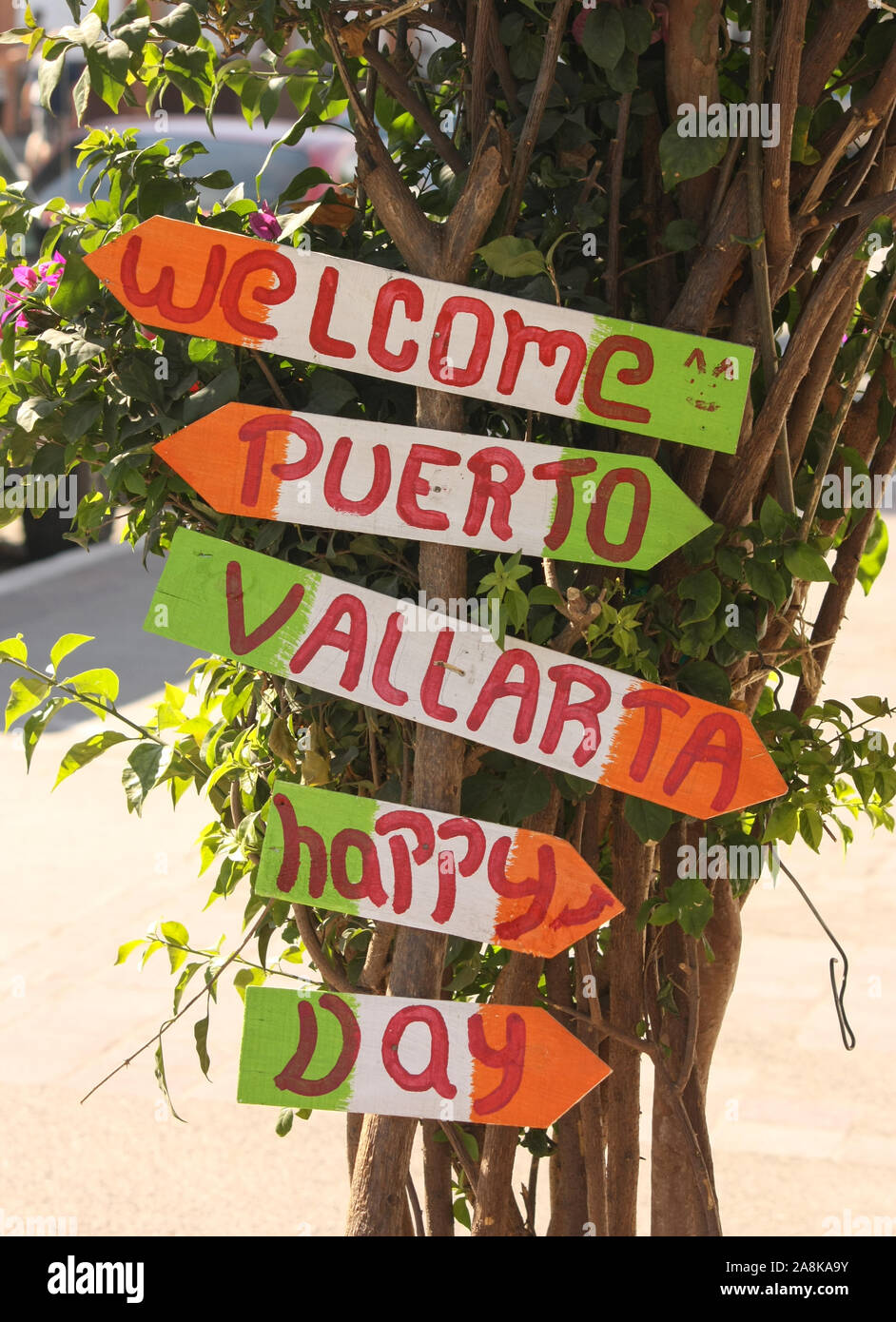 Patriotisches farbenfrohes Schild, das Besucher in der Innenstadt von Puerto Vallarta willkommen heißt und alle zu einem glücklichen Tag auffordert. Stockfoto