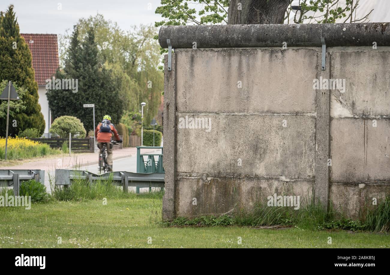15. Mai 2019, Thüringen Großensee: ein Radfahrer kreuzt die Straße an einem kleinen Stück Wand wie der Rest der DDR grenzbefestigung zwischen Großensee (vorne) in Thüringen und Kleinensee (zurück) in Hessen. Foto: Frank Rumpenhorst/dpa Stockfoto