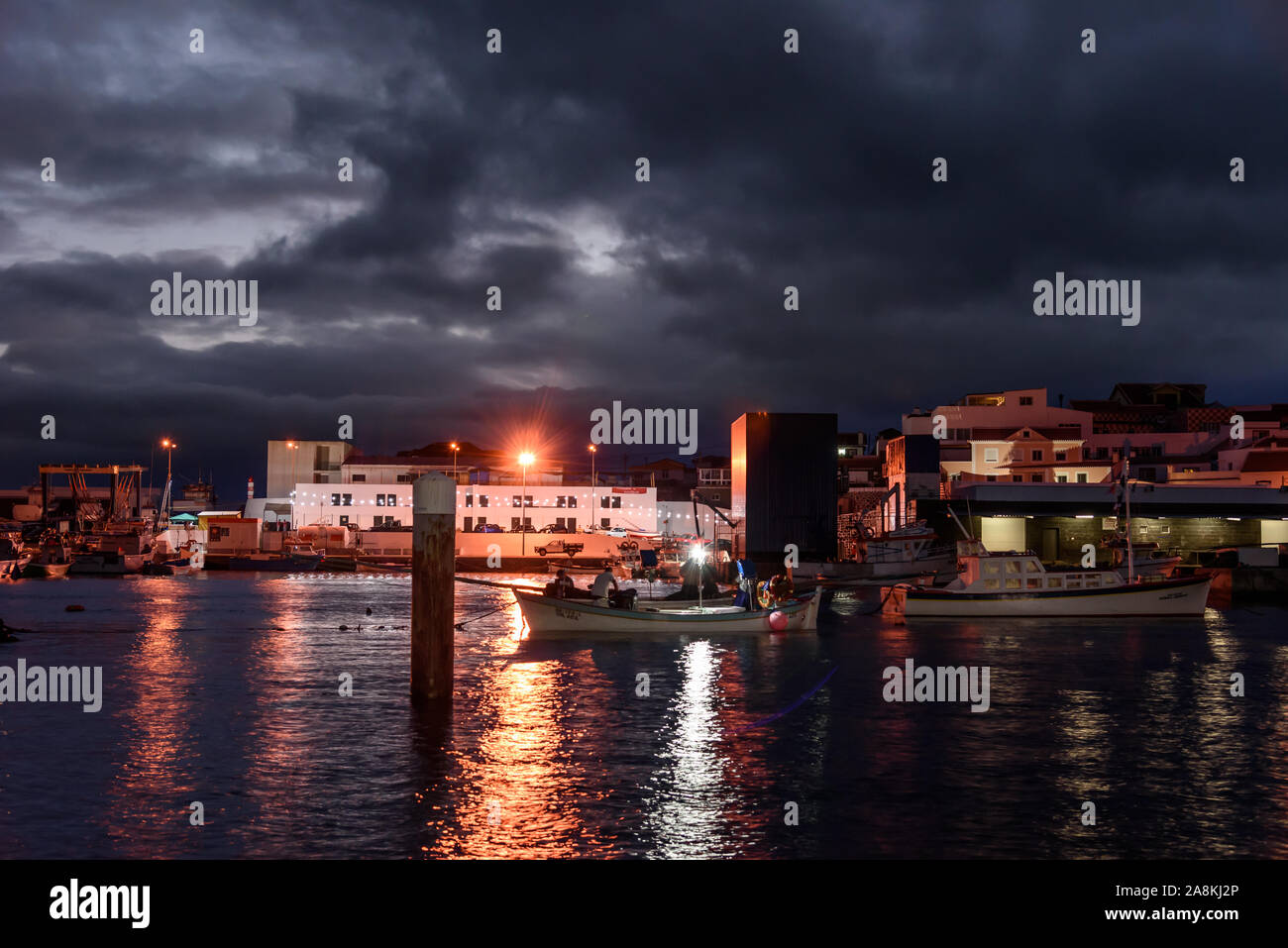 Blick auf den Hafen von Sao mateus während der Nacht mit streetlight Reflexion und Boote. Azoren Portugal Stockfoto