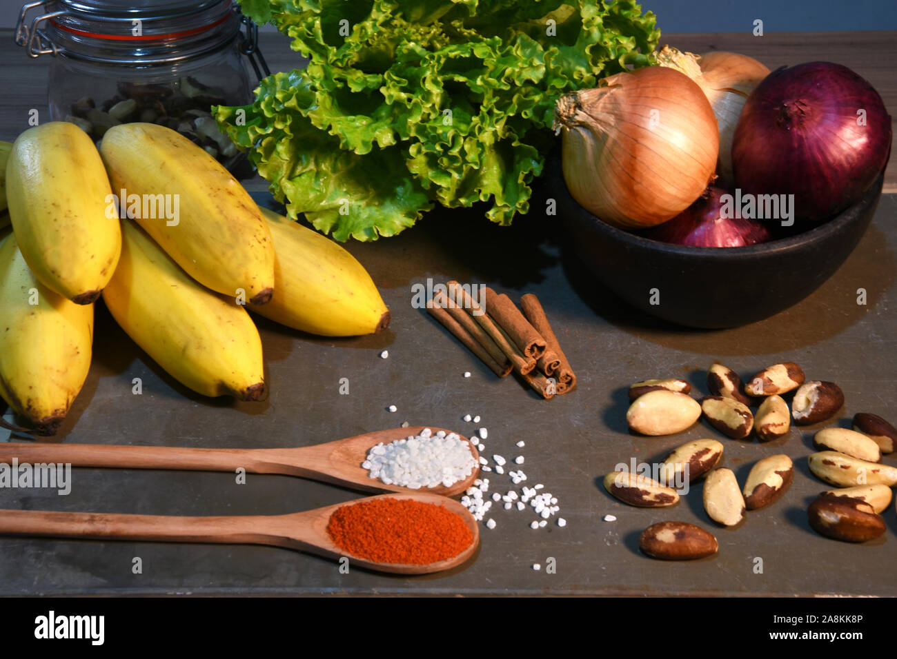 Steintisch mit Kartoffeln Zwiebeln Knoblauch Banane und Gewürze ...