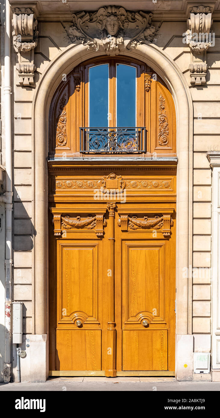Paris, eine alte Holztür, mit einem auf dem Türsturz gehauenen Kopf, typisches Gebäude im Marais Stockfoto