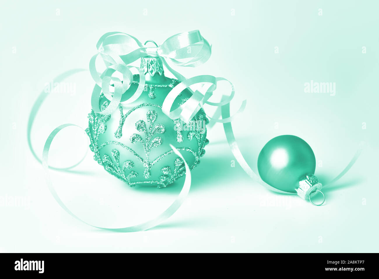 Kreative rosa monochrome gefiltert Close-up auf zwei Trinkets, Glas Weihnachtskugeln getönten in trendigen Biskaya grüne Farbe. Frohe Weihnachten und ein Frohes Neues Ja Stockfoto
