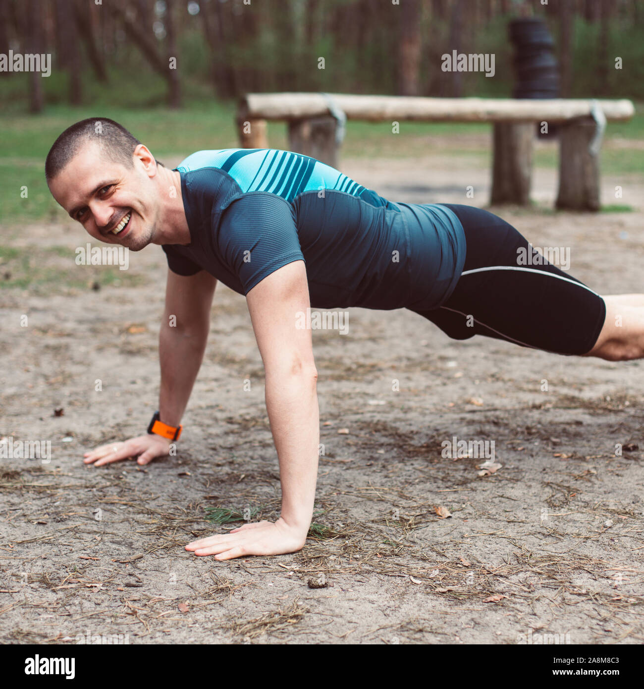Athletischer Mann lächelnd, während Sie liegestütze Outdoor Stockfoto