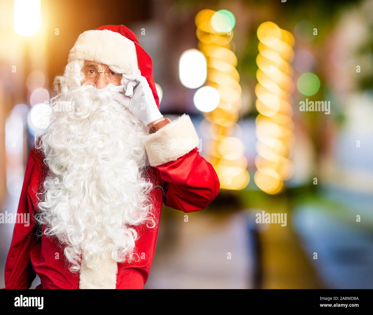 Mittleres Alter stattlicher Mann mit Santa Claus Kostüm und Bart ständigen Mund und Lippen als zip mit den Fingern. Geheimnis und leise, Tabu sprechen Stockfoto