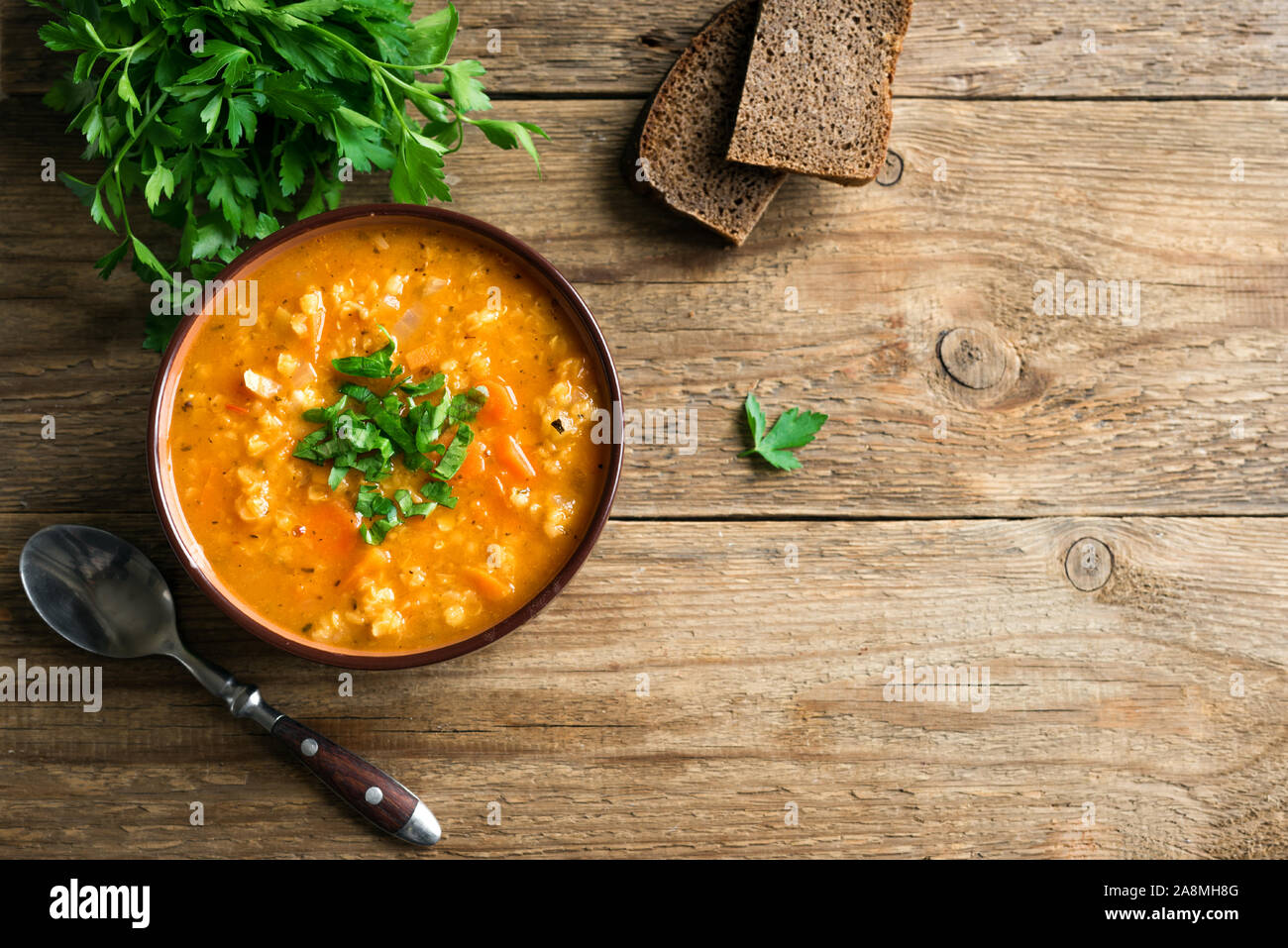 Rote Linsensuppe oder Dal auf hölzernen Hintergrund, Ansicht von oben, kopieren. Traditionelle türkische oder arabische Linsen und Gemüse würzige Suppe, gesunde vegane Ernährung. Stockfoto