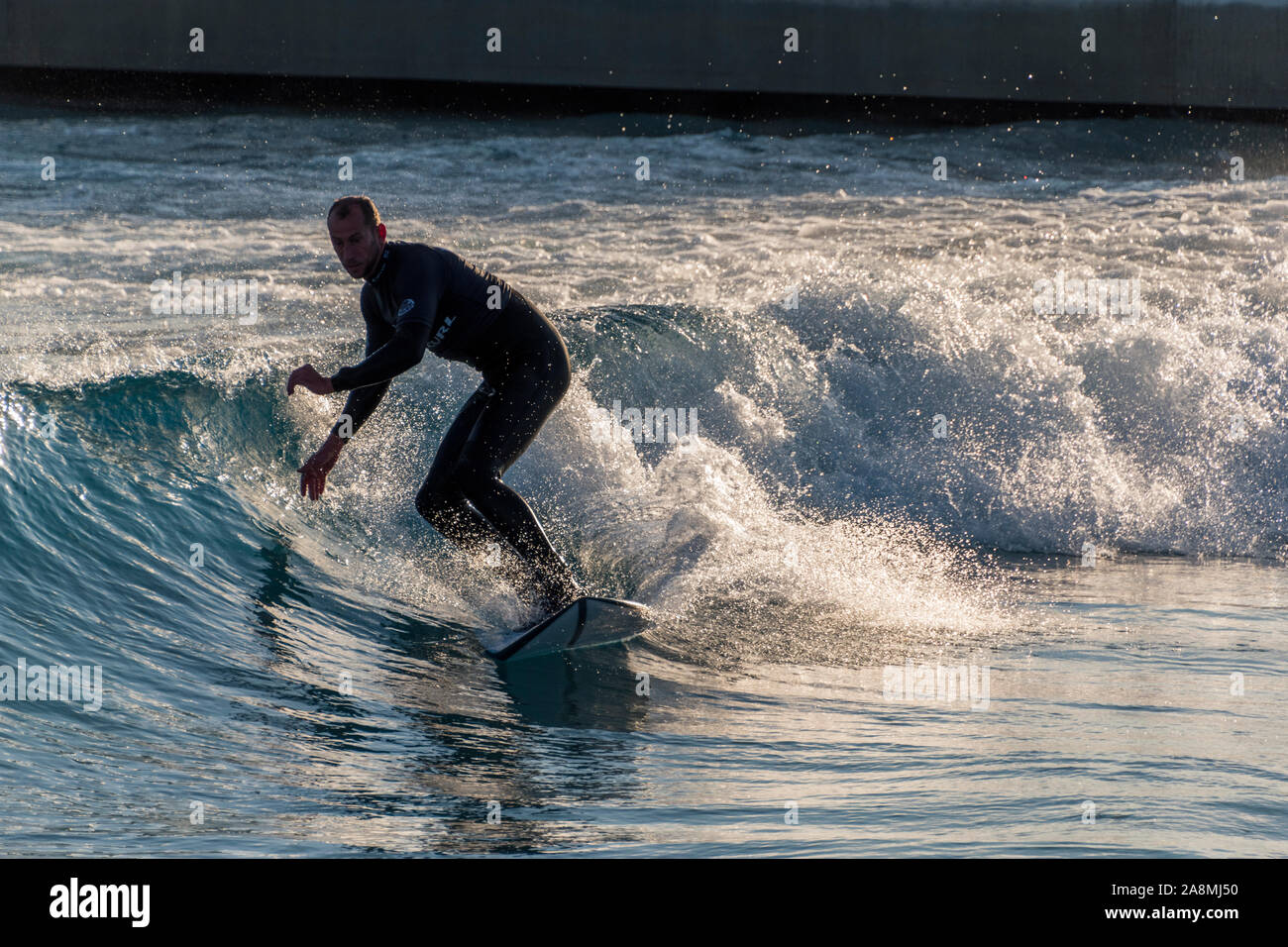 Surfer reiten Erweiterte ebene Wellen an der Welle, Bristol, eine künstliche Binnen surfen See in der Nähe von Bristol, UK. Stockfoto