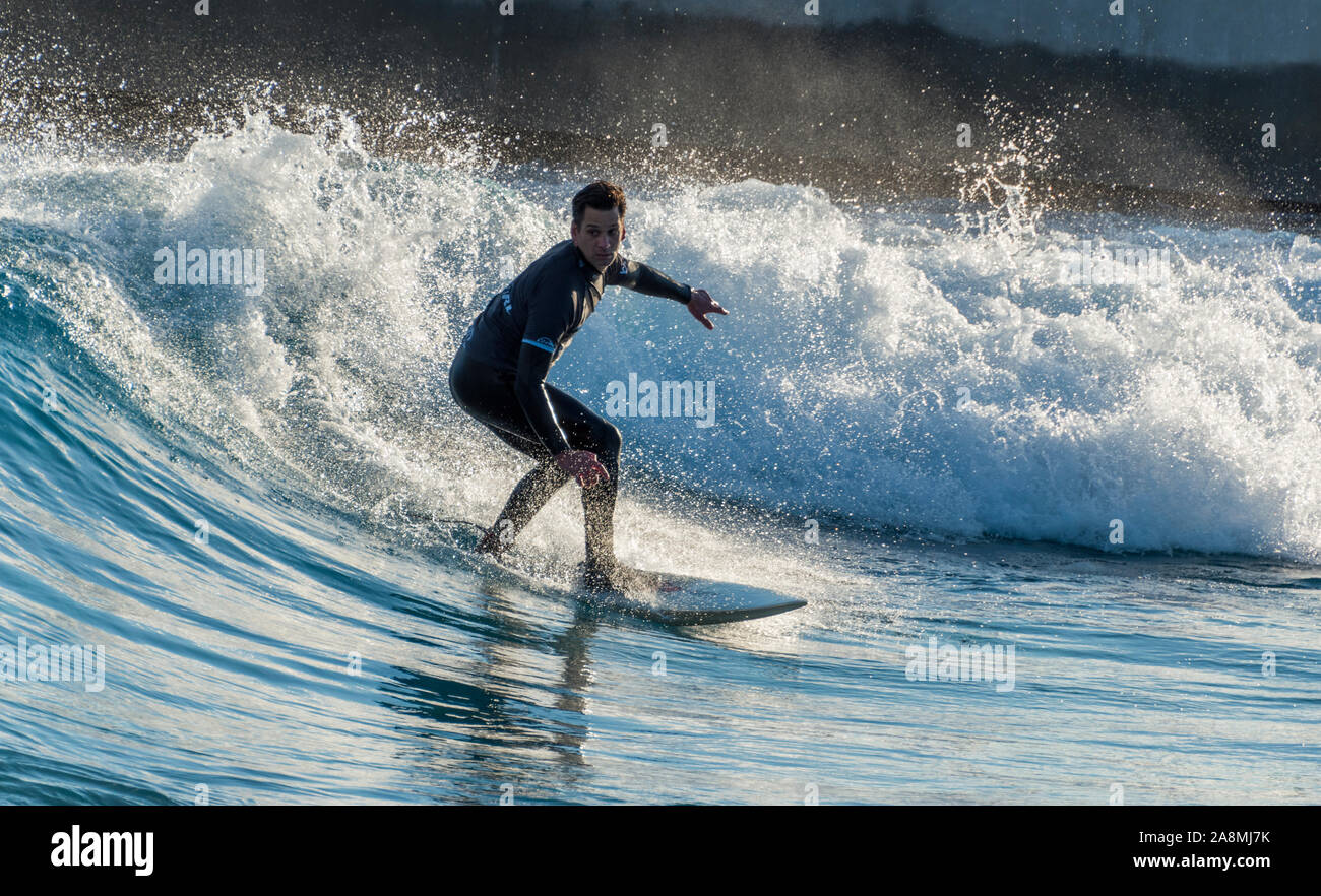 Surfer reiten Erweiterte ebene Wellen an der Welle, Bristol, eine künstliche Binnen surfen See in der Nähe von Bristol, UK. Stockfoto