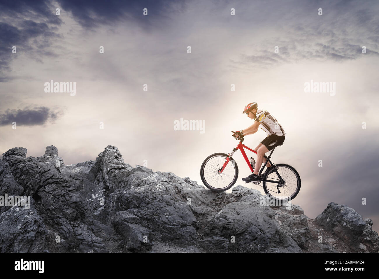 Reiten Mountainbike auf den Felsen gegen bewölkten Himmel. Stockfoto