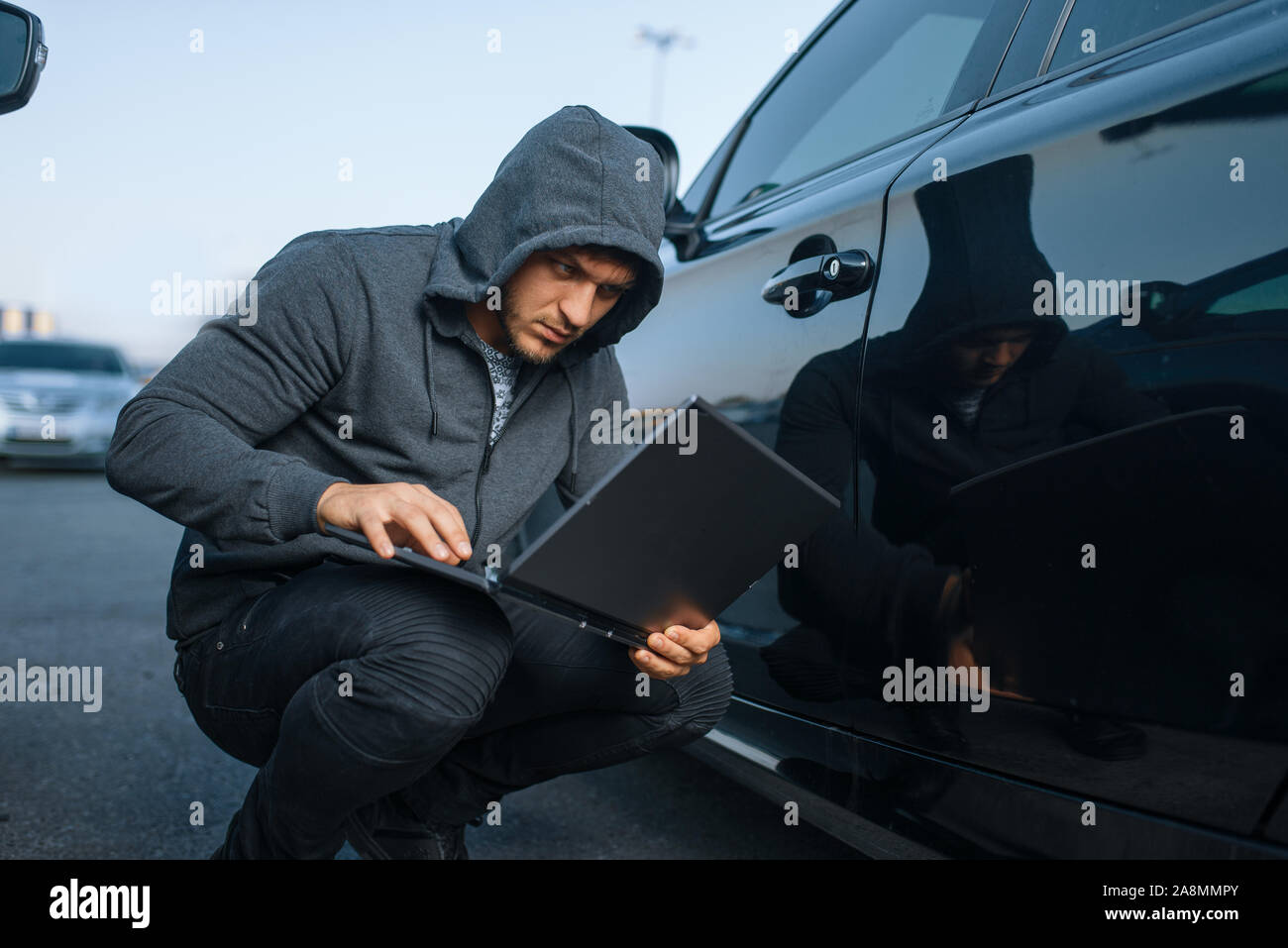 Car Thief mit Laptop hacken Alarm System Stockfoto