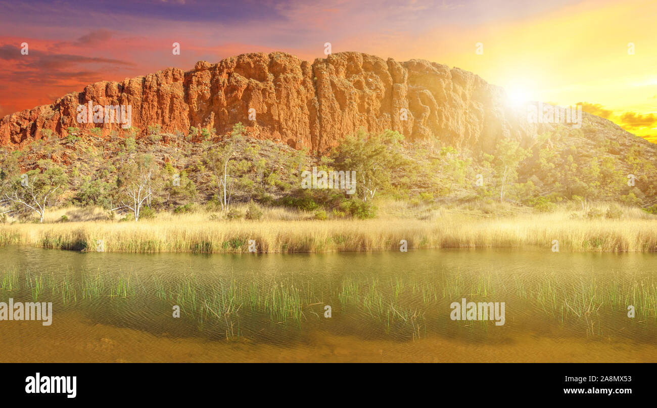 Glen Helen Gorge änderungen Farben mit Sonnenuntergang Lichts auf permanenten Wasserloch, Zentrale australische Outback. Malerischen West MacDonnell Ranges rock Stockfoto