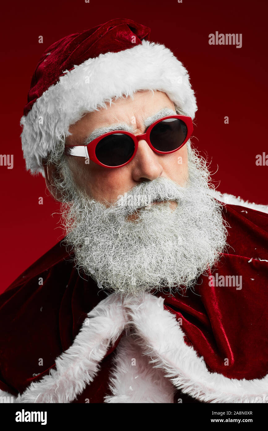 Kopf und Schultern Portrait von cool Santa Claus mit Sonnenbrille über den roten Hintergrund stehend Stockfoto