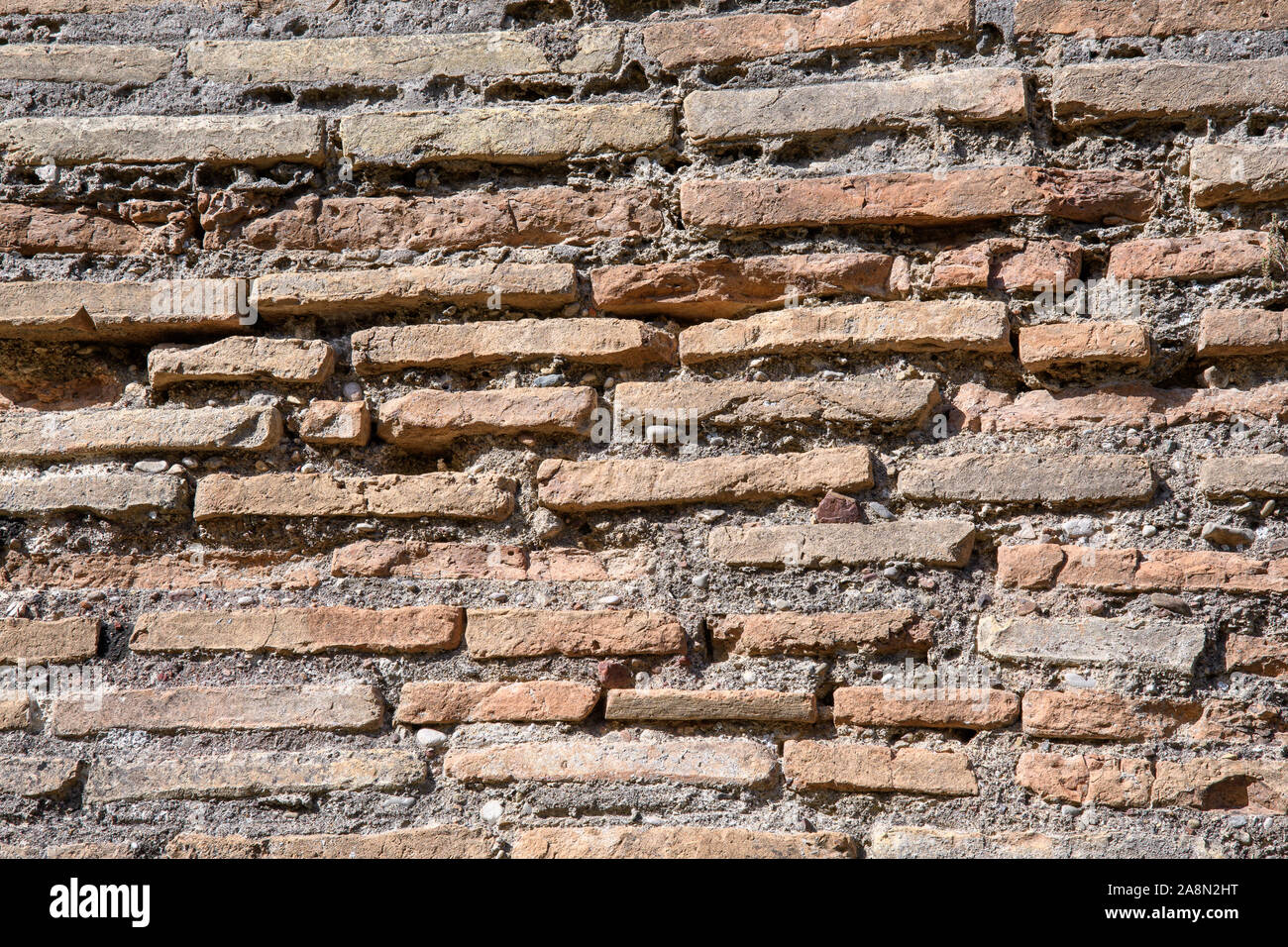Ein Fragment der alten Mauer aus Stein von einem der Tempel der griechischen Antike Olympia. Antikes Mauerwerk. Stockfoto