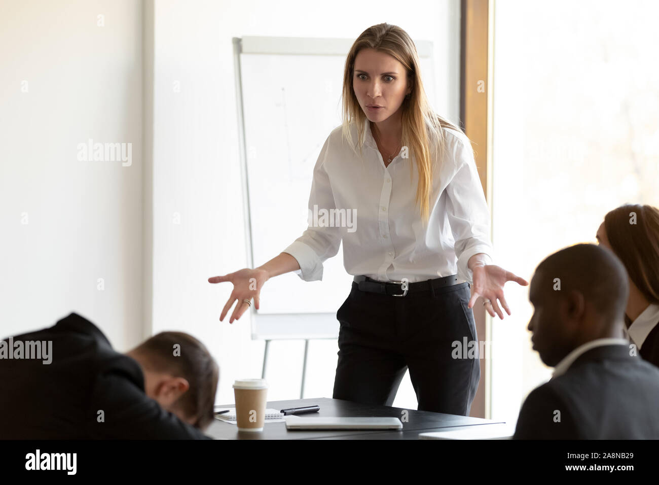 Wütend Geschäftsfrau durch Mitarbeiter dösen am Briefing verwirrt Stockfoto